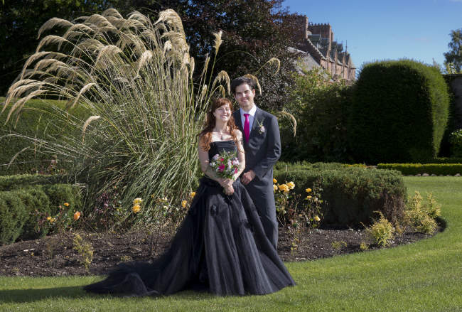 Een trouwfoto in de tuin van een romantisch kasteel